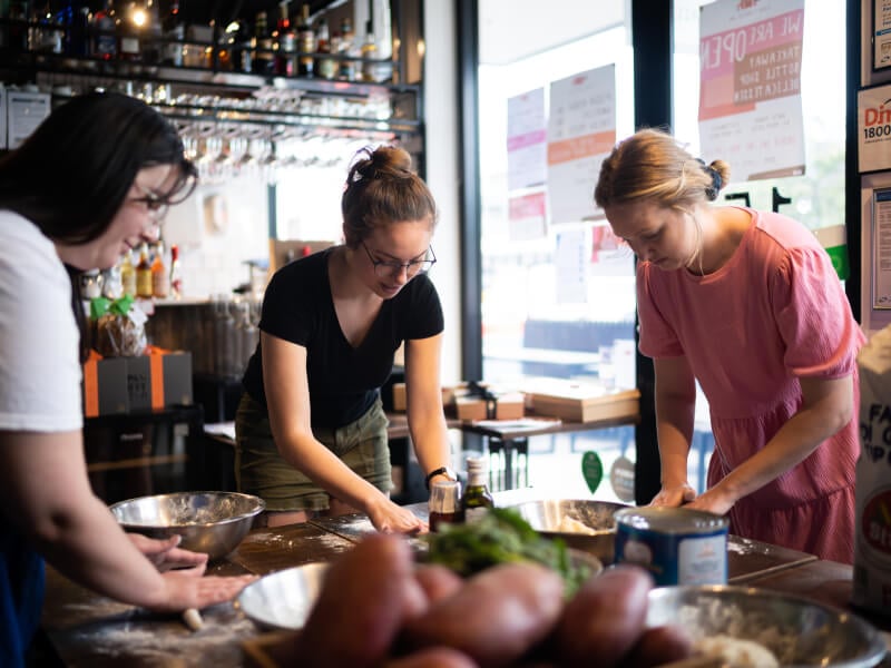 Team of employees cooking together at a corporate cooking class in Brisbane